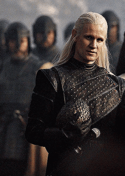 A Man With Long White Hair Is Standing In Front Of A Group Of Soldiers Holding A Dragon . GIF