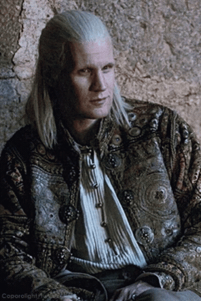 A Man With Long White Hair Is Wearing A Jacket With Buttons GIF