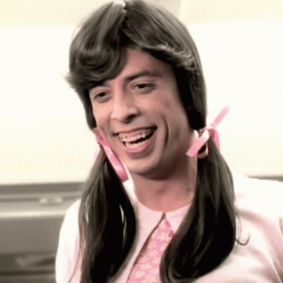 A Man With Pigtails And Braces Smiles For The Camera GIF