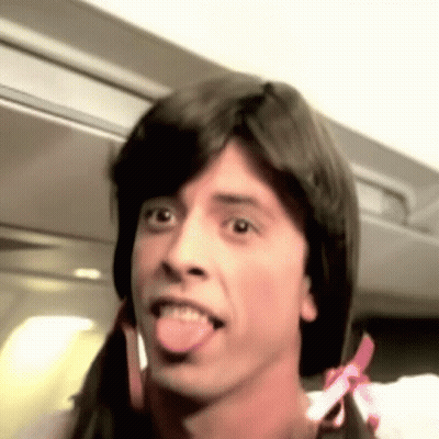 A Man With Pigtails Is Sticking His Tongue Out . GIF