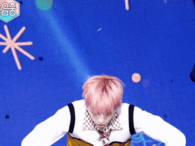 A Man With Pink Hair Is Dancing In Front Of A Blue Background With A Fox Logo GIF