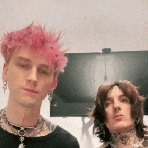 A Man With Pink Hair Is Standing Next To Another Man With Black Hair And Tattoos . GIF