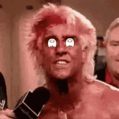 A Man With Pink Hair Is Talking Into A Microphone And Has Ghosts In His Eyes . GIF