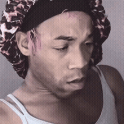 A Man With Pink Hair Is Wearing A Leopard Print Bonnet GIF