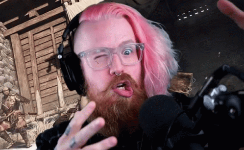 A Man With Pink Hair Is Wearing Headphones And Making A Face GIF