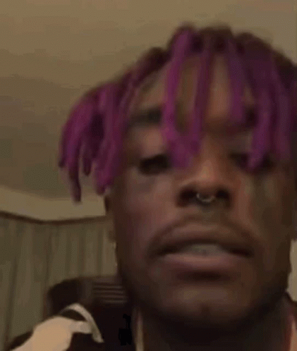 A Man With Purple Hair Is Making A Funny Face . GIF