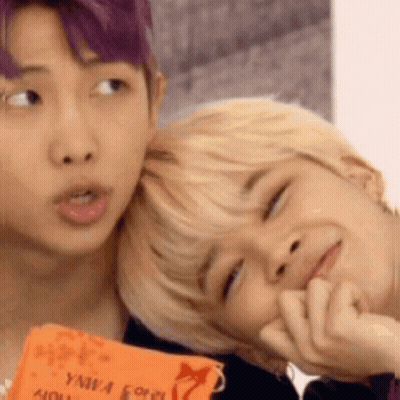 A Man With Purple Hair Is Putting His Head On Another Man 'S Head . GIF