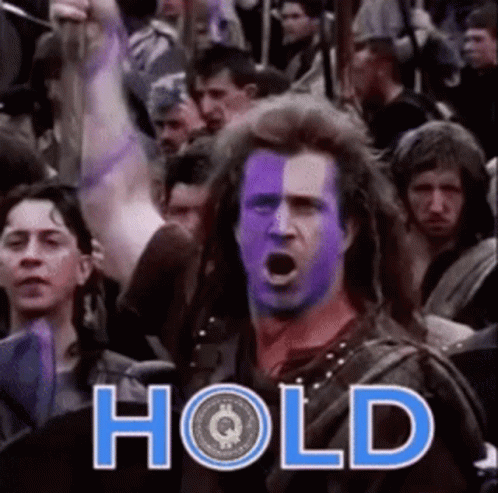 A Man With Purple Paint On His Face Is Standing In Front Of A Crowd With The Word Hold Written On It GIF