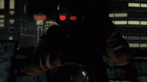 A Man With Red Eyes Is Standing In Front Of A Sign That Says ' Exit ' On It GIF