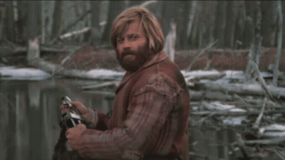 A Man With Red Hair And A Beard Is Holding A Camera In His Hand GIF
