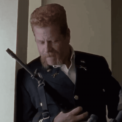 A Man With Red Hair And A Beard Is Holding A Gun And Wearing A Military Uniform GIF