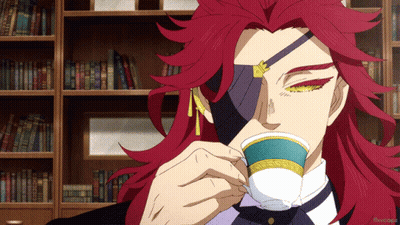 A Man With Red Hair Is Drinking From A Cup In Front Of Bookshelves GIF