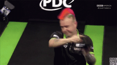 A Man With Red Hair Is Playing Darts In Front Of A Bbc America Logo GIF