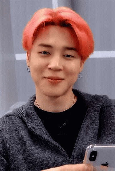 A Man With Red Hair Is Smiling While Holding An Apple Iphone GIF