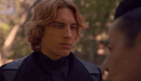 A Man With Red Hair Is Standing Next To A Woman In A Black Jacket . GIF