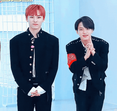 A Man With Red Hair Is Standing Next To Another Man GIF
