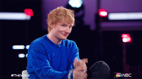 A Man With Red Hair Is Wearing A Blue Sweater And Clapping GIF