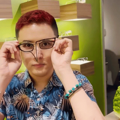 A Man With Red Hair Is Wearing Glasses And A Bracelet On His Wrist GIF