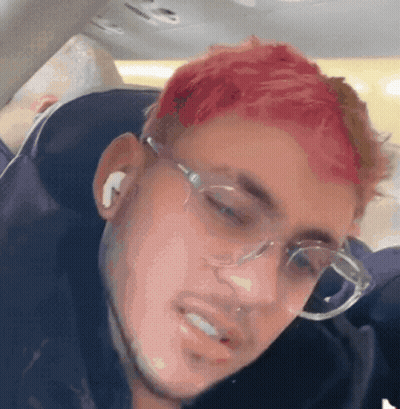 A Man With Red Hair Is Wearing Glasses And Earbuds GIF