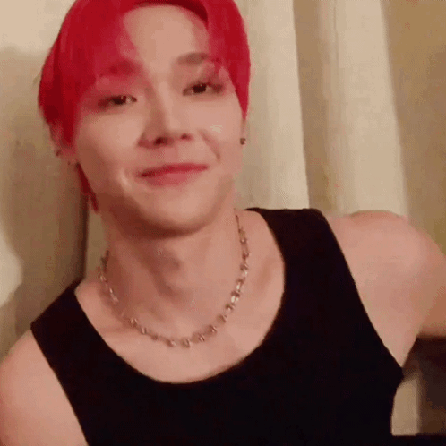 A Man With Red Hair Wearing A Black Tank Top And A Necklace . GIF