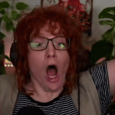 A Man With Red Hair Wearing Glasses And Headphones Is Making A Surprised Face . GIF