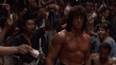 A Man With Red Paint On His Body Is Standing In Front Of A Crowd GIF
