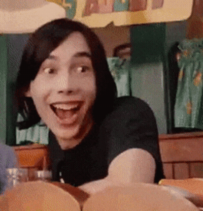 A Man With Short Hair Is Smiling With His Mouth Open GIF