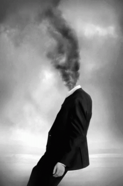 A Man With Smoke Coming Out Of His Head In A Black And White Photo GIF