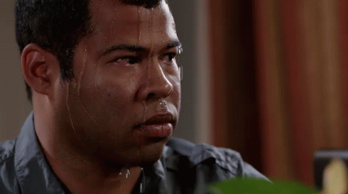 A Man With Sweat Coming Out Of His Face Is Looking At The Camera . GIF