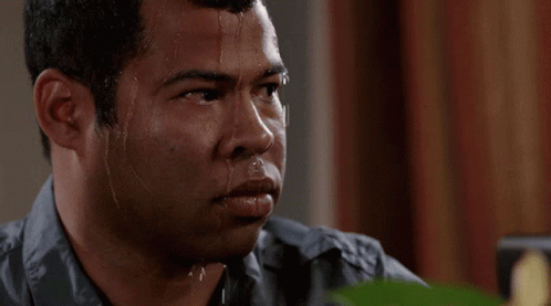 A Man With Sweat Running Down His Face Is Looking At Something GIF