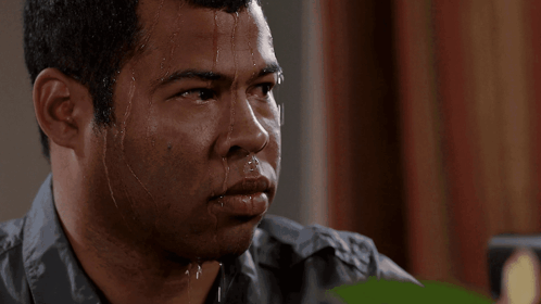 A Man With Sweat Running Down His Face Looks At The Camera GIF