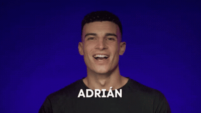 A Man With The Name Adrian On His Shirt Smiles GIF