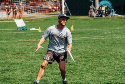 A Man With The Number 15 On His Shorts Is Holding A Frisbee On A Field GIF