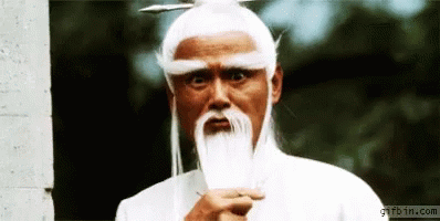 A Man With White Hair And A Beard Is Standing In Front Of A Gifbin.com Sign GIF