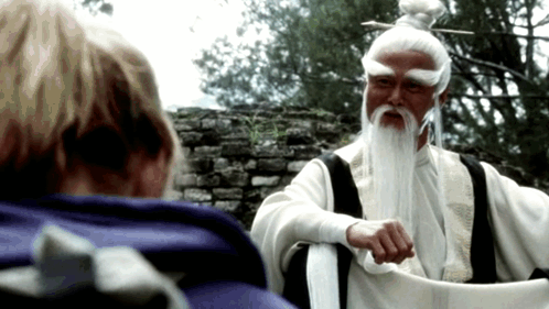 A Man With White Hair And A Beard Is Talking To Another Person GIF