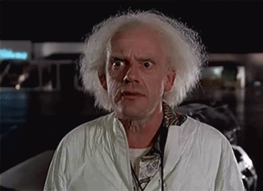 A Man With White Hair And A Beard Is Wearing A Lab Coat And Headphones . GIF