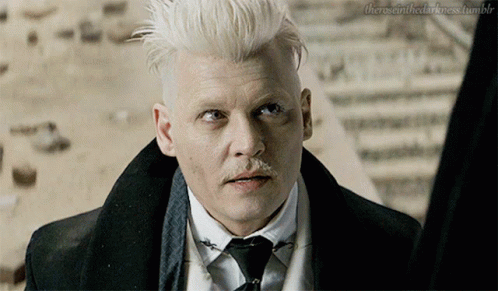 A Man With White Hair And A Mustache Is Looking At Something GIF