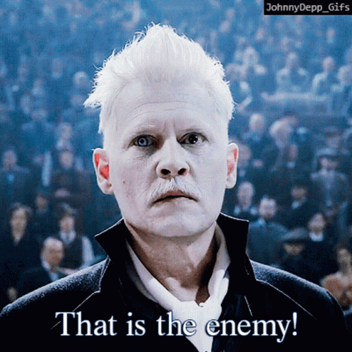 A Man With White Hair And A Mustache Says That Is The Enemy In Front Of A Crowd GIF