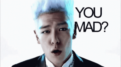 A Man With White Hair Is Making A Funny Face In Front Of A Sign That Says You Mad GIF