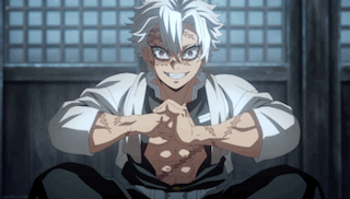 A Man With White Hair Is Sitting Down With His Hands Folded In Front Of Him . GIF