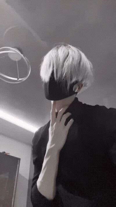A Man With White Hair Is Wearing A Black Mask . GIF