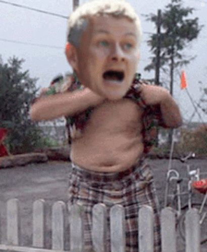 A Man Without A Shirt Is Behind A Fence With His Mouth Open GIF