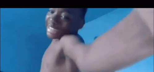 A Man Without A Shirt Is Being Punched In The Face By Another Man . GIF