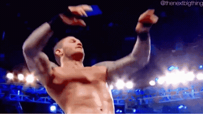A Man Without A Shirt Is Dancing In A Wrestling Ring With His Arms In The Air . GIF