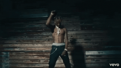 A Man Without A Shirt Is Dancing In Front Of A Wooden Wall And The Word Vevo Is On The Bottom GIF