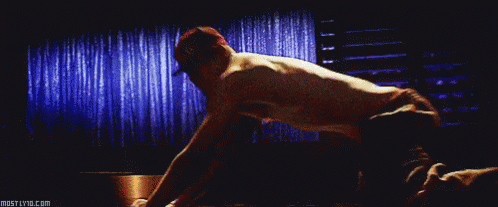 A Man Without A Shirt Is Doing Push Ups In Front Of A Window . GIF