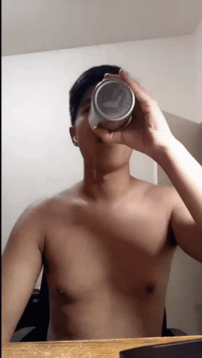 A Man Without A Shirt Is Drinking From A Can With The Word Puma On It GIF