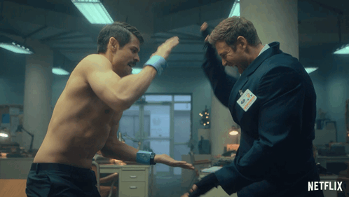 A Man Without A Shirt Is Fighting Another Man With A Name Tag That Says Netflix On It GIF