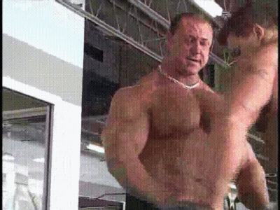 A Man Without A Shirt Is Holding A Woman In His Arms In A Gym GIF