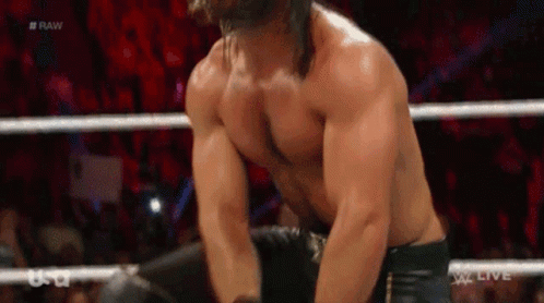 A Man Without A Shirt Is In A Wrestling Ring With A Crowd In The Background . GIF